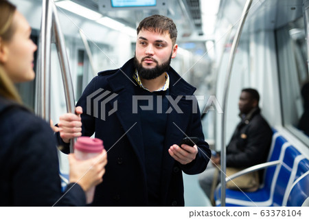 Young man talking with woman in subway Young man talking with woman in subway 63378104
