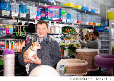 Portrait of happy man with his chihuahua dog visiting pet supplies shop 63378105