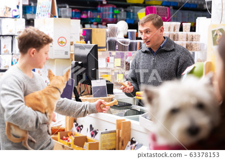 People with dogs shopping in pets shop 63378153