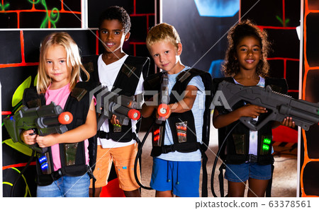 Multiracial kids posing on lasertag arena Multiracial kids posing on lasertag arena 63378561