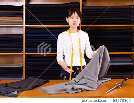 Portrait of chinese girl tailor in a mens clothing store Portrait of chinese girl tailor in a mens clothing store 63378563