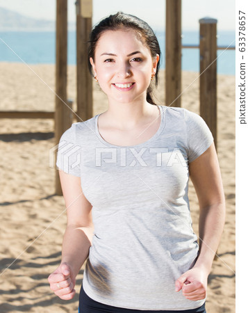 sporty girl running on beach by ocean in morning sporty girl running on beach by ocean in morning 63378657