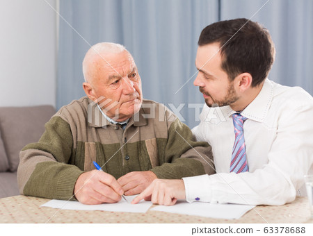Man signing papers at home 63378688