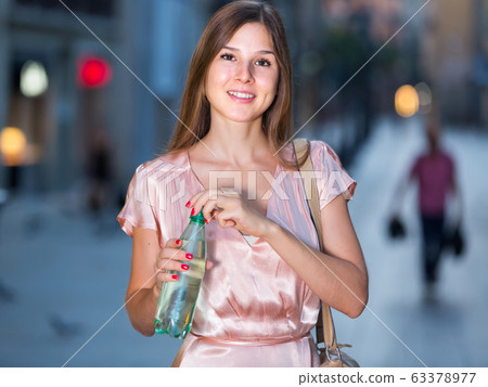 Young female drinking water in historic city center Young female drinking water in historic city center 63378977