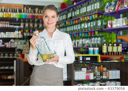 Salesgirl suggesting perfume on tap 63379056
