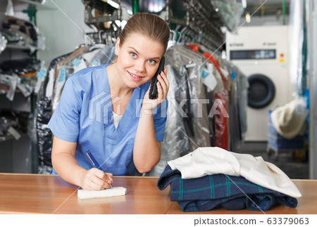 Worker of laundry talking on phone 63379063