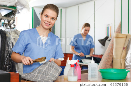 Girl working in dry cleaning Girl working in dry cleaning 63379166