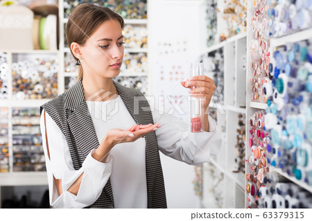 Woman choosing buttons in shop Woman choosing buttons in shop 63379315