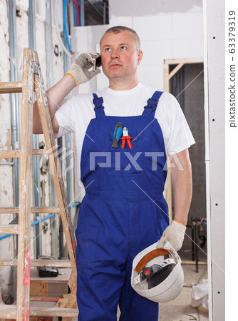 Worker having serious phone conversation Worker having serious phone conversation 63379319