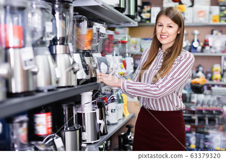 Young woman choosing blender in household appliances shop Young woman choosing blender in household appliances shop 63379320