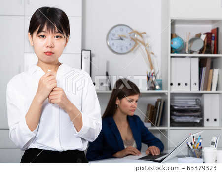 Boss dismissing an employee. Chinese woman crying in company office Boss dismissing an employee. Chinese woman crying in company office 63379323