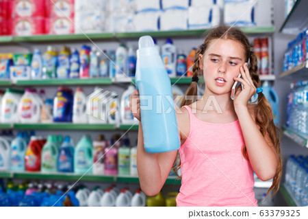 Girl choosing household detergent 63379325