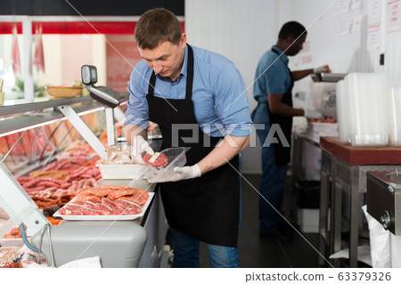 Butchers working behind counter Butchers working behind counter 63379326