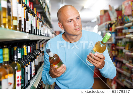 man looking wine man looking wine 63379327