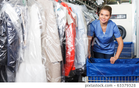 Girl working in dry cleaning Girl working in dry cleaning 63379328
