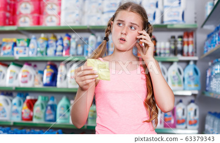 girl with shopping list talking on telephone 63379343