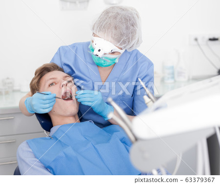 Young man on dental checkup in modern dentist office 63379367