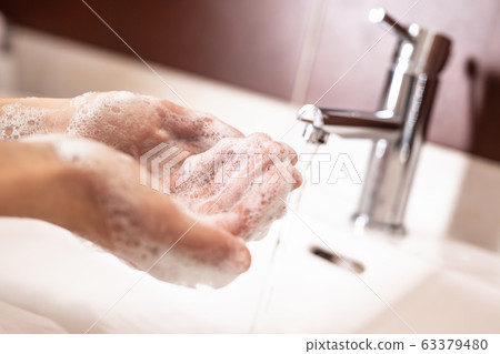 Washing hands with water and liquid soap in the Washing hands with water and liquid soap in the 63379480