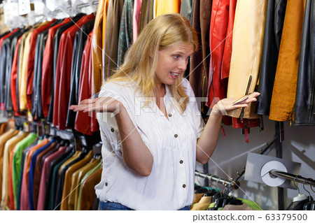 Displeased woman choosing leather clothes 63379500