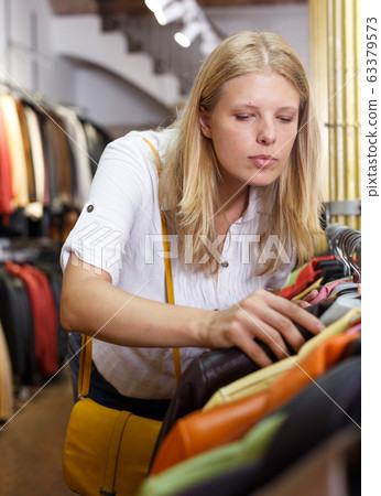 Woman choosing leather jacket 63379573