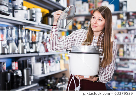 Girl buying slow cooker Girl buying slow cooker 63379589