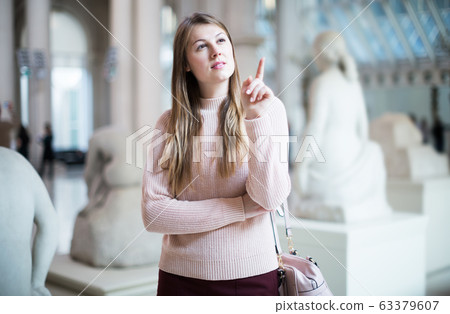 Woman standing in art museum Woman standing in art museum 63379607