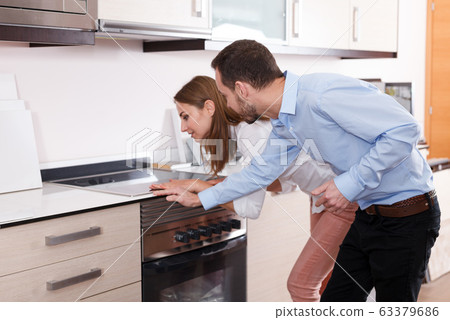 Couple choosing household appliances for kitchen Couple choosing household appliances for kitchen 63379686