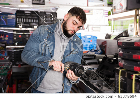 Man is buying new impact wrench 63379694
