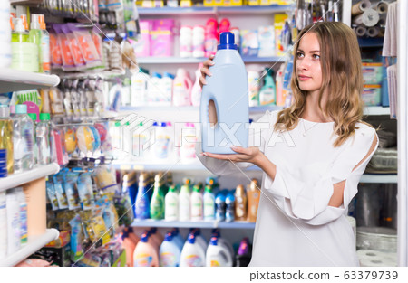 Attractive woman holding bottle of rinse aid Attractive woman holding bottle of rinse aid 63379739