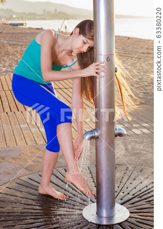 Sport woman is resting with shower for massage of legs Sport woman is resting with shower for massage of legs 63380220