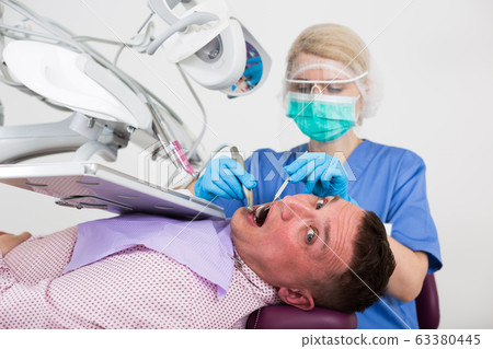 Man visiting dentist Man visiting dentist 63380445