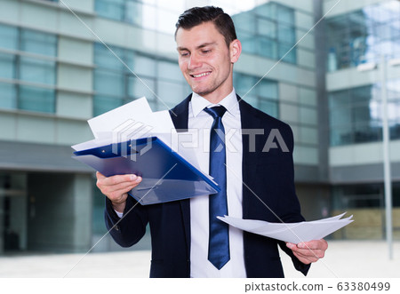 Professional businessman is examining documents before signing Professional businessman is examining documents before signing 63380499
