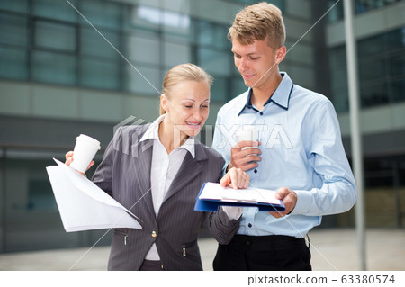 Couple enterpreneurs are examining documents Couple enterpreneurs are examining documents 63380574