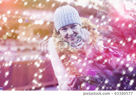 Adult woman is choosing Christmas tree in the market Adult woman is choosing Christmas tree in the market 63380577