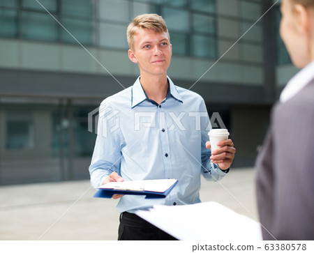Young manager is talking with partner before signing contract Young manager is talking with partner before signing contract 63380578