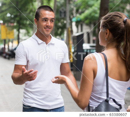 Man and woman talking on street 63380607