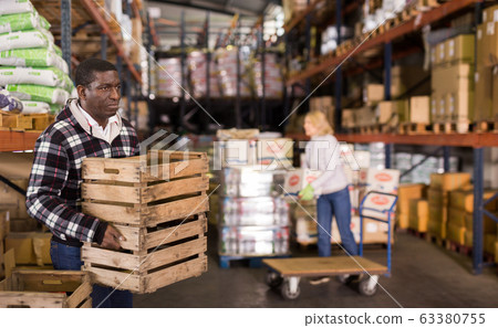 Warehouse worker stacking wooden boxes Warehouse worker stacking wooden boxes 63380755