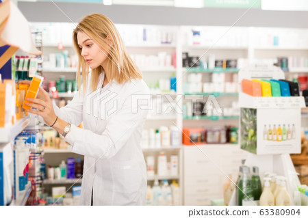 Female pharmacist arranging medicines Female pharmacist arranging medicines 63380904