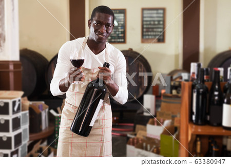 salesman with wineglass and bottle of wine offering to taste product salesman with wineglass and bottle of wine offering to taste product 63380947