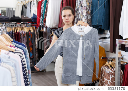 Woman choosing new clothes in shop Woman choosing new clothes in shop 63381178