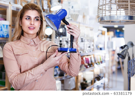 Housewife buying table lamp 63381179