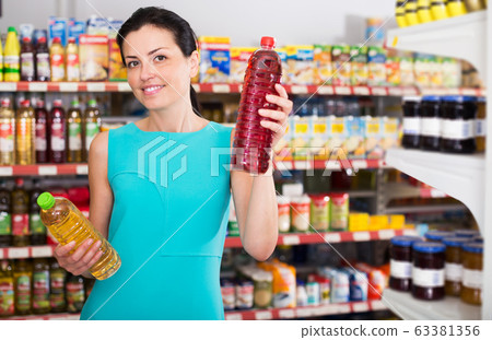 Woman choosing different oil in bottle Woman choosing different oil in bottle 63381356