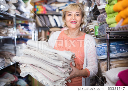 customer female choosing cotton tablecloths in the textile store customer female choosing cotton tablecloths in the textile store 63381547