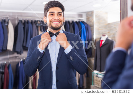 Customer is trying on butterfly in front of the mirror Customer is trying on butterfly in front of the mirror 63381822