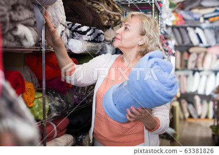 mature woman purchaser choosing soft plaids 63381826