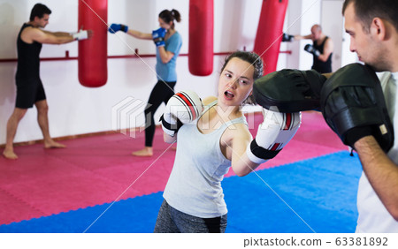 Sportswomen competing in colored boxing gloves Sportswomen competing in colored boxing gloves 63381892