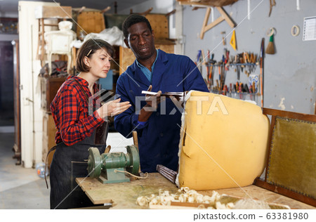 Artisans inspecting vintage armchair 63381980