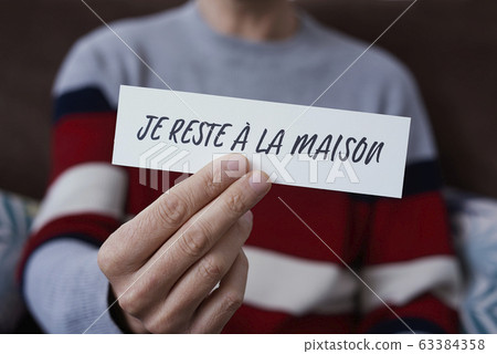 man showing the message I stay at home in french 63384358