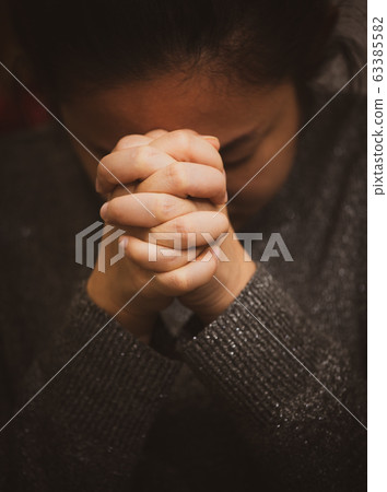 An Asian woman is praying clinging to God with what she wishes for healing An Asian woman is praying clinging to God with what she wishes for healing 63385582