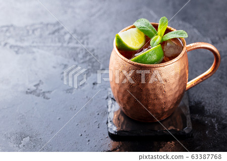 Cold Moscow Mules cocktail with ginger beer, vodka, lime. Grey stone background. Copy space. Cold Moscow Mules cocktail with ginger beer, vodka, lime. Grey stone background. Copy space. 63387768